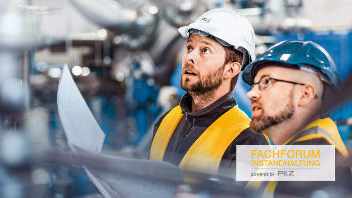 Male colleagues analysing machine in industry